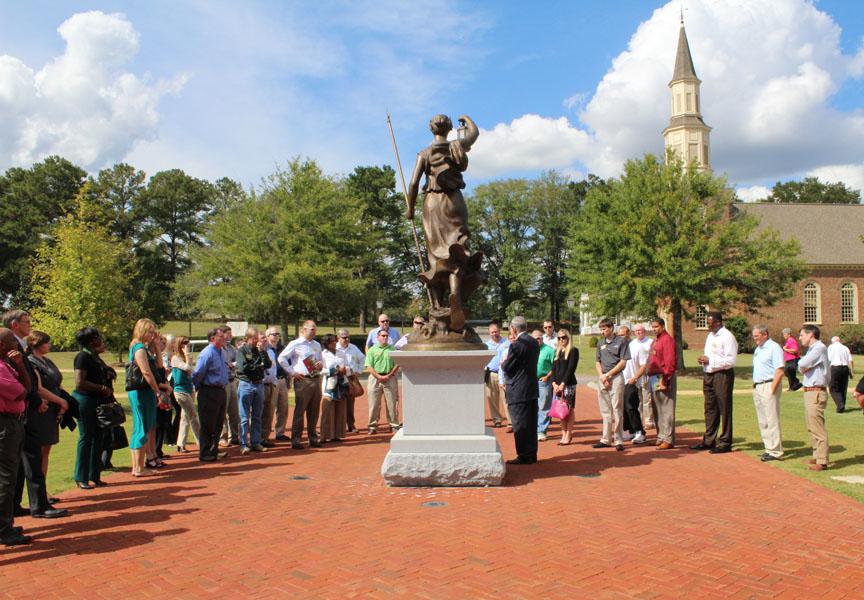 people standing around the statue at the entrance to the Veteran's Shrine